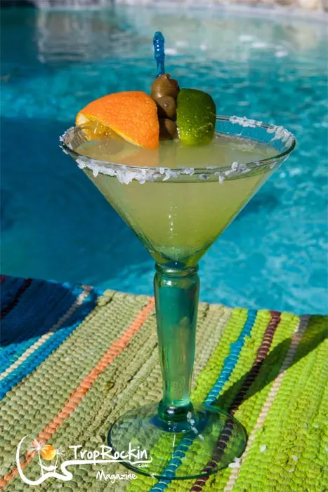 The Mexican Martini Drink with garnish of olives, orange and lime by the pool.