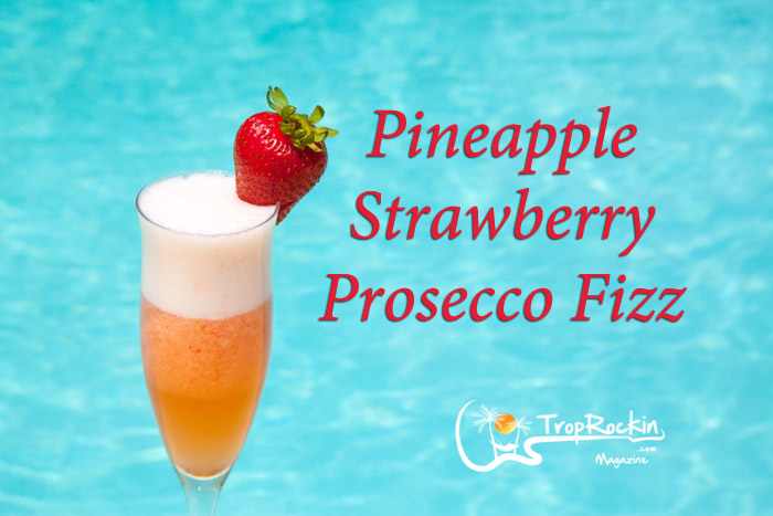 Pineapple Strawberry Mimosa in a Champagne Flute with Strawberry Garnish by the Pool