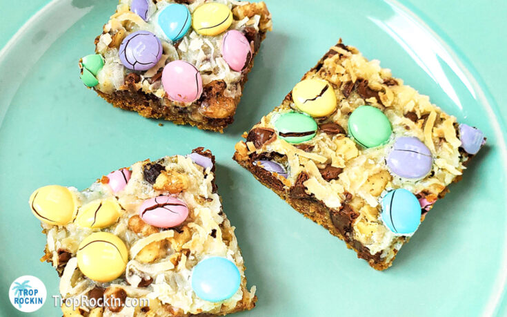 Three easter magic bars cut in squares on a pastel green plate.