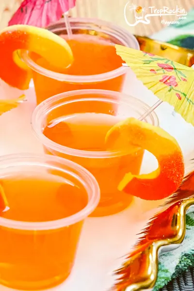 Peach Vodka Jello Shots garnished with Peach Rings and Drink Umbrellas up close.