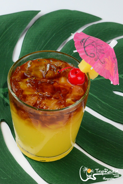 Pineapple rum punch drink with a dark rum floater with garnish.