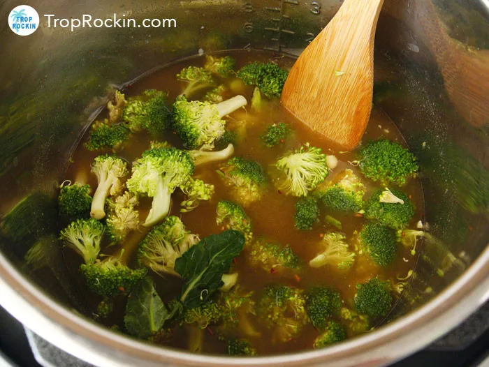 Adding broccoli into the instant pot.