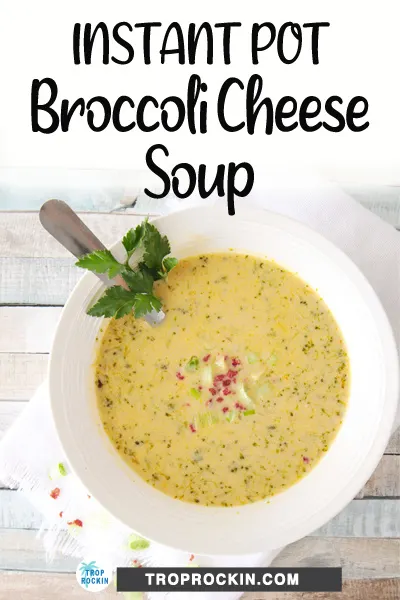 Bowl of broccoli cheese soup with optional garnishes of green onions and bacon bits.