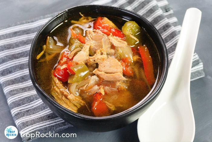 Instant Pot Chicken Fajita Soup in a Bowl with a spoon on gray counter and dish towel.