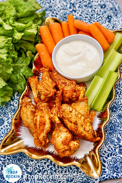Air fryed Bufflao Wings on serving tray with clelery, carrots and ranch dressing for dipping.
