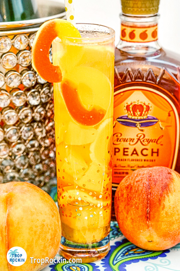 Crown peach drink with fresh peaches and peach rings on counter top.