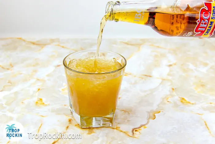 Pouring Cream Soda into cocktail glass.