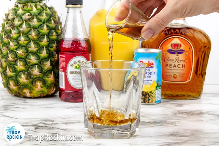 Pouring Crown Royal Peach into cocktail glass.