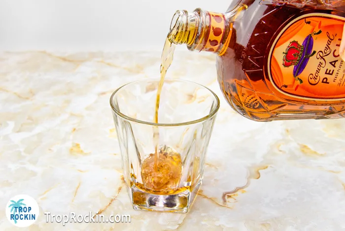 Pouring Peach Crown Royal into drink glass.