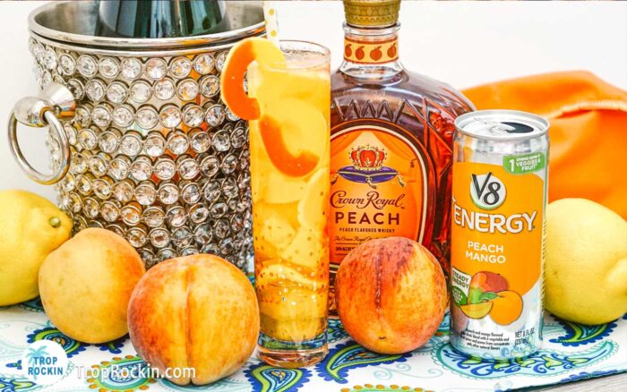 Crown Royal Peach Mixed Drink with ripe peaches, crown royal peach bottle and a can of peach mango juice.