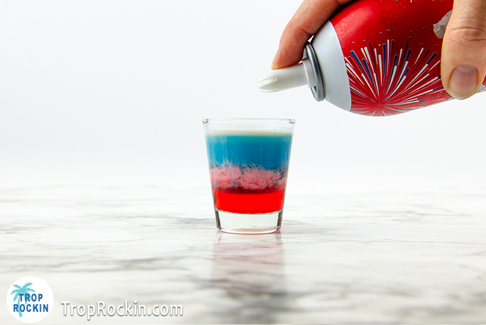 4th of July shot with red white and blue layers and a can of Reddi Whip whipped cream.