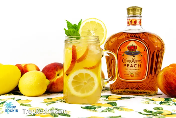 Peach Crown Drinks: Lemonade drink with Crown Royal Peach Bottle in background.