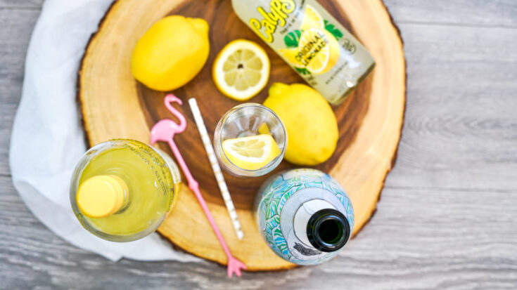 Adding lemon slice to cocktail glass.