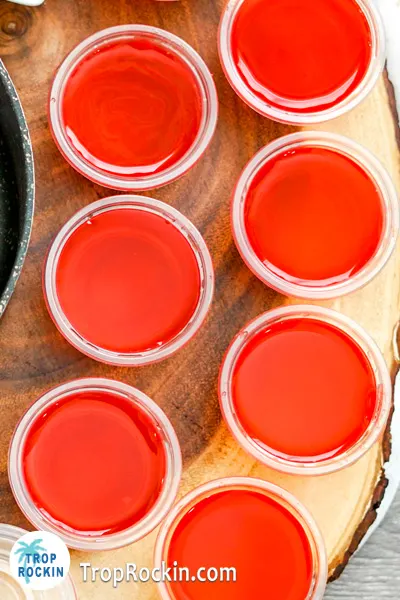 Watermelon jello shots displayed on cutting board without garnish.