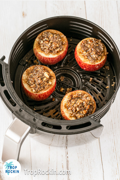 Apples stuffed with pecan topping in the air fryer basket.