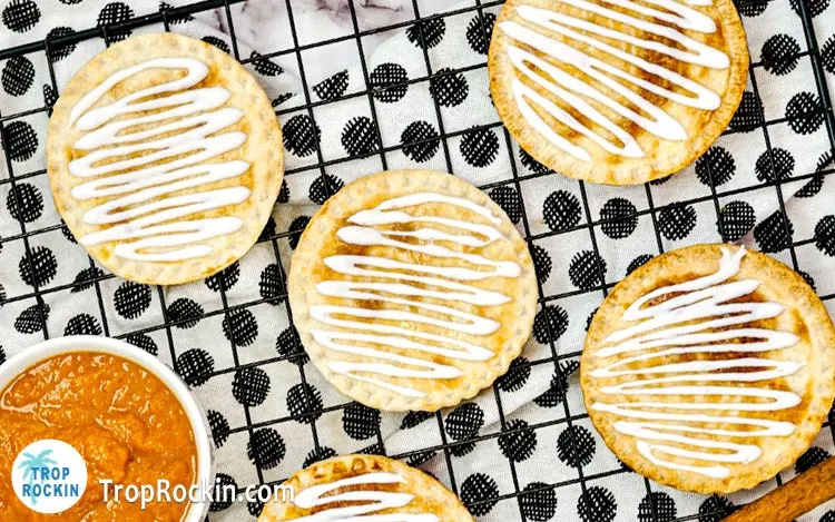 Air Fryer Pumpkin Hand Pies with icing on cooling rack.