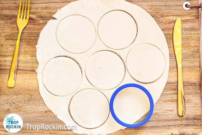 Pie crust rolled out and circles cut into it with a round cookie cutter.