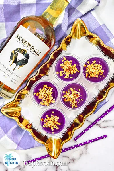 Skrewball Peanut Butter Whiskey Jello Shots on serving tray and a bottle of Skrewball next to it.