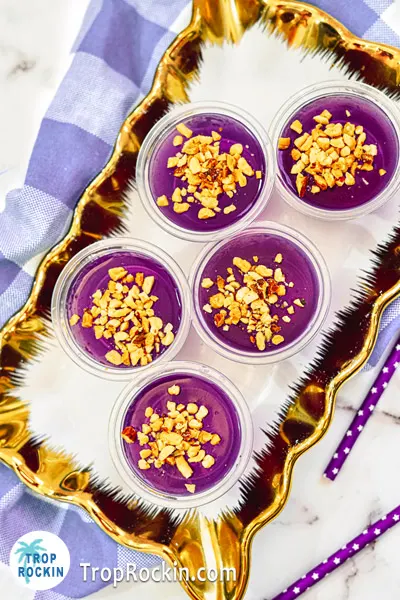 Peanut Butter Whiskey and Jello Shots on serving tray with chopped peanuts on top. Beautiful purple jello shots.