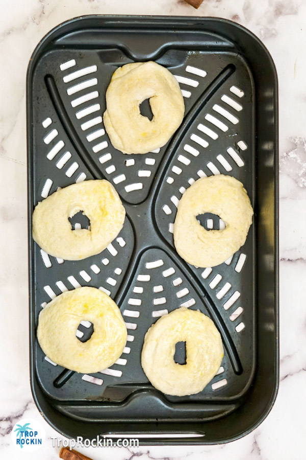Biscuit donuts in air fryer basket.