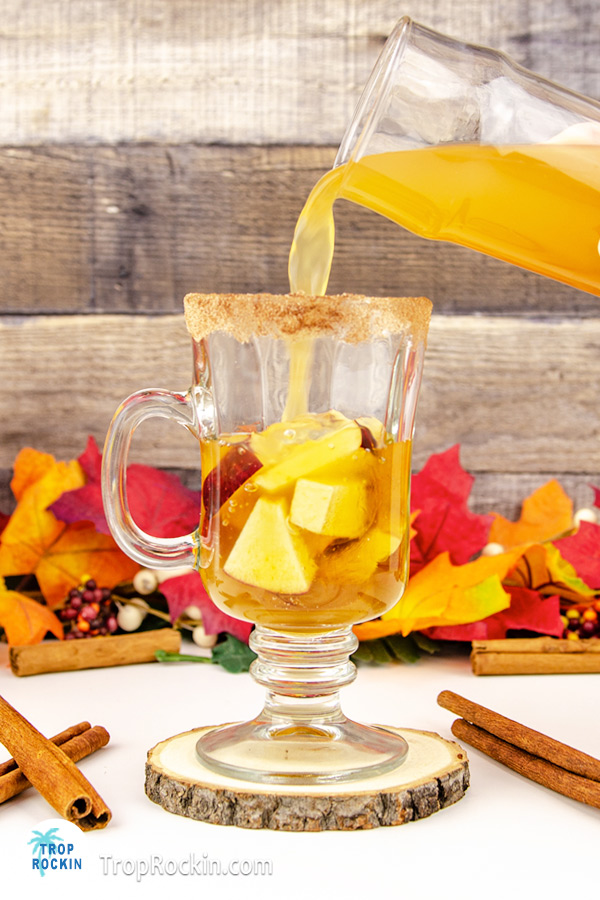 Pouring hot apple cider into glass.