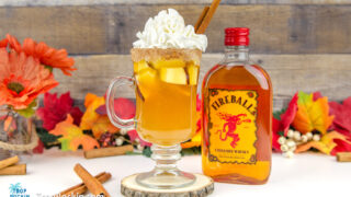 Fireball Apple Cider drink with Fireball Whisky bottle in background.