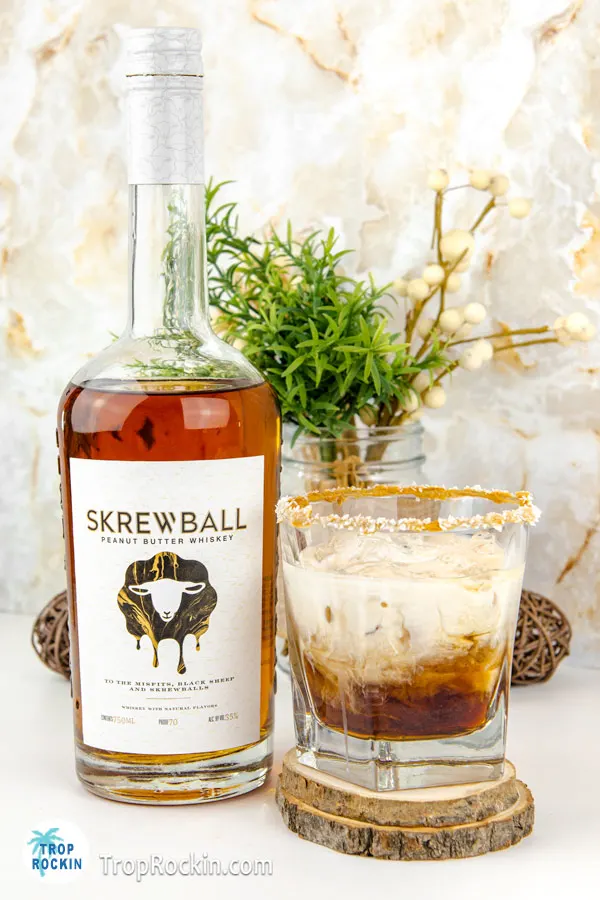 Skrewball White Russian drink with Skrewball Whiskey bottle.