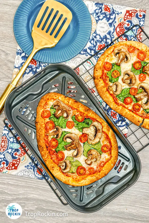 Air fryer basket with naan bread pizza.