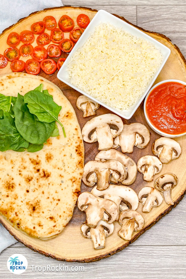 Air Fryer Naan Pizza Ingredients on cutting board.