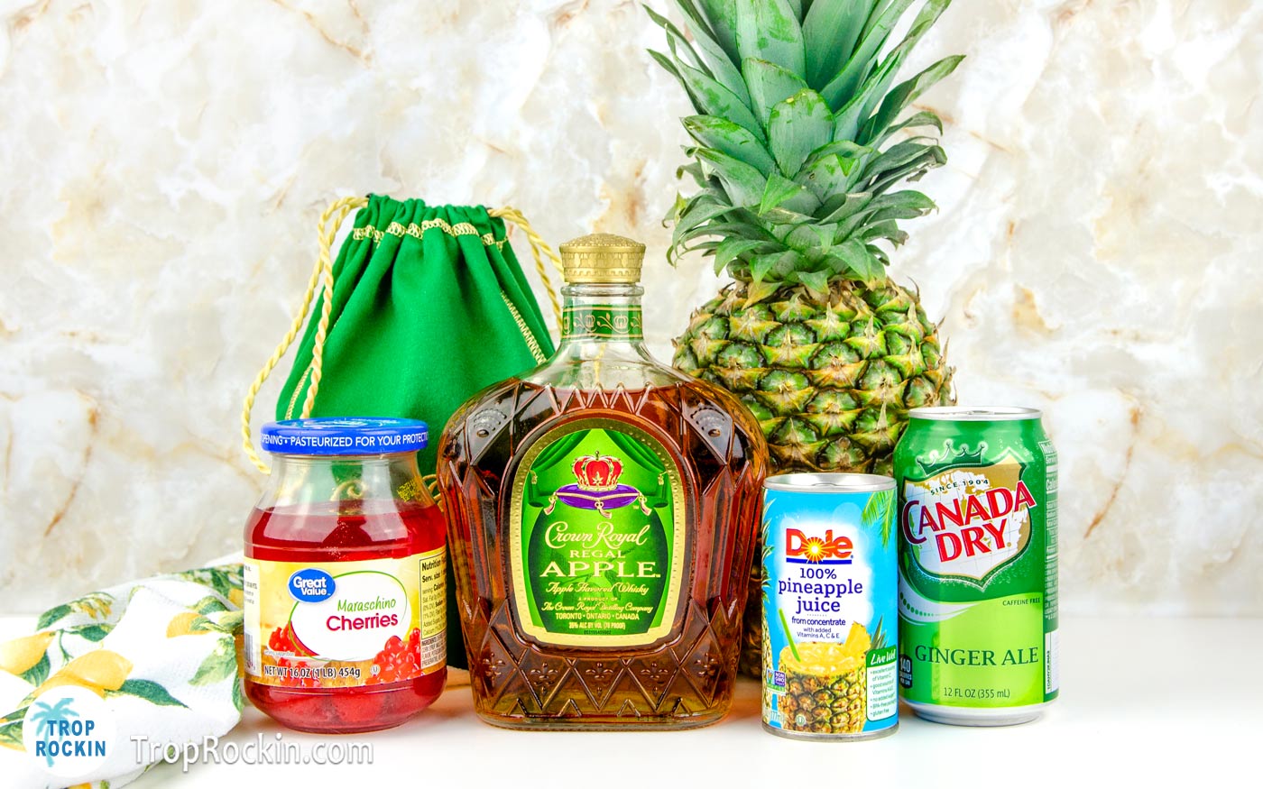 Crown Apple and Pineapple Juice cocktail ingredients displayed on table top.