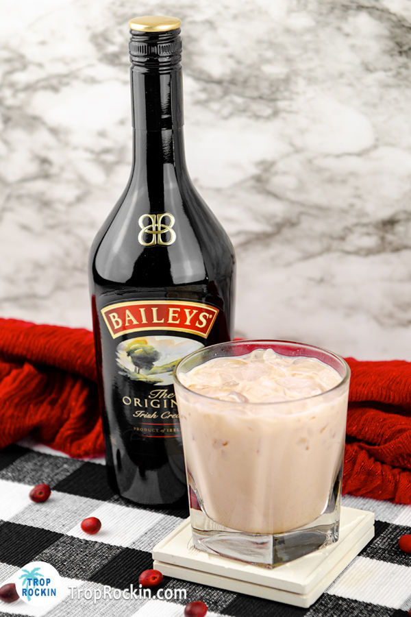 Bailey's White Russian drink with a bottle of Bailey's Original Irish Cream in background.