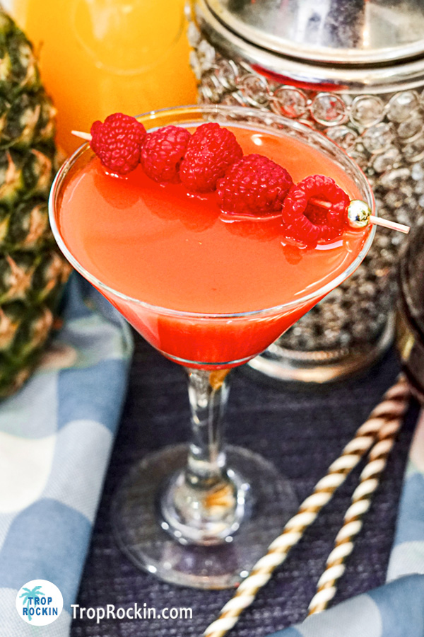 Chambord French Martini from a top view with a skewer of raspberries on top laying across the martini glass.