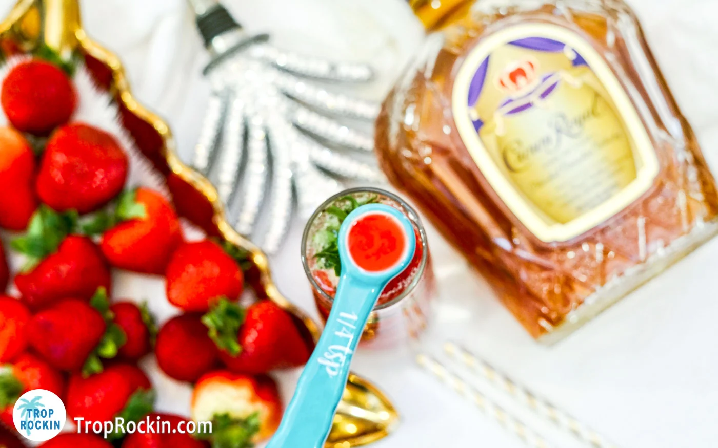 Adding strawberry syrup into the crown royal drink.