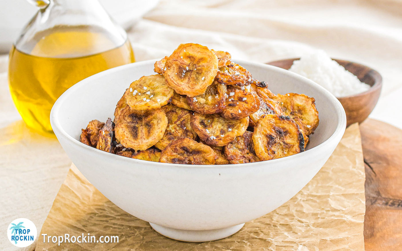 Air fryer banana chips stacked in a white bowl.