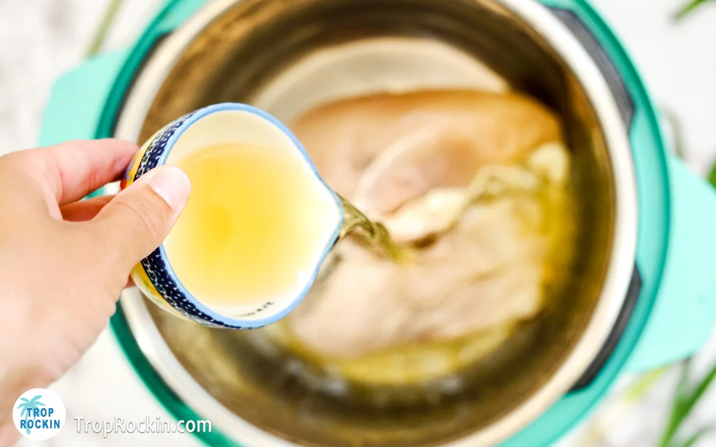 Pouring chicken broth into the Instant Pot.