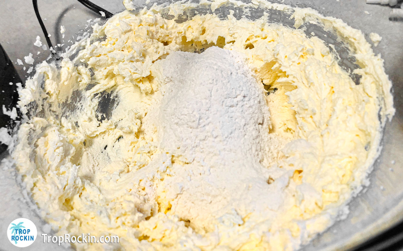 Adding flour mixture into mixing bowl.