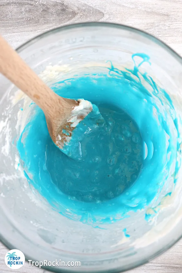 Melted butter and mini marshmallows with blue food coloring in a microwave-save bowl.