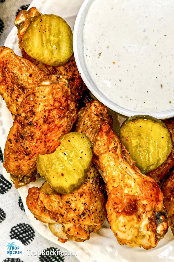 Close up view of air fryer nashville hot wings and pickle slices on a plate.