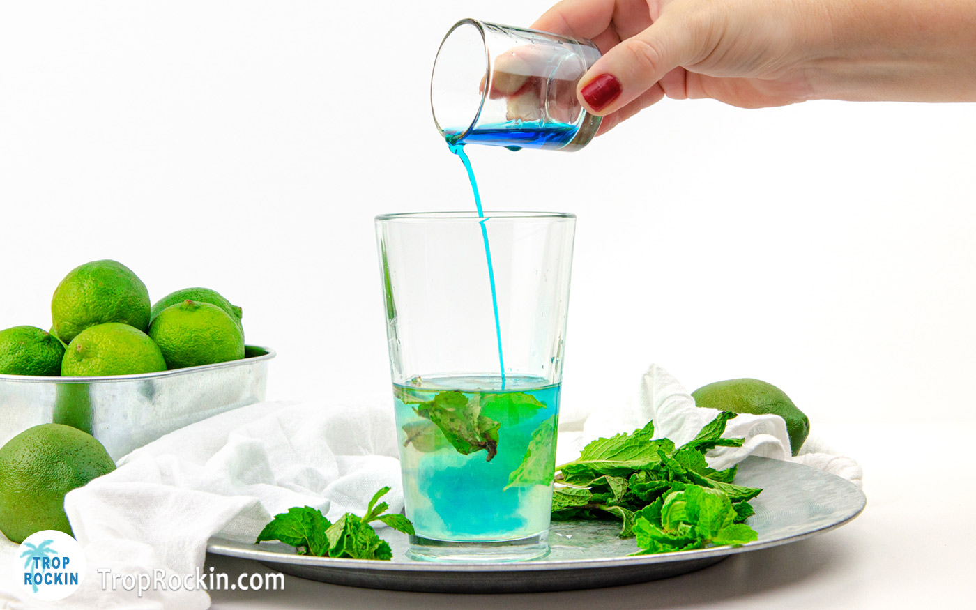 Pouring Blue Curacao into the Mojito drink.