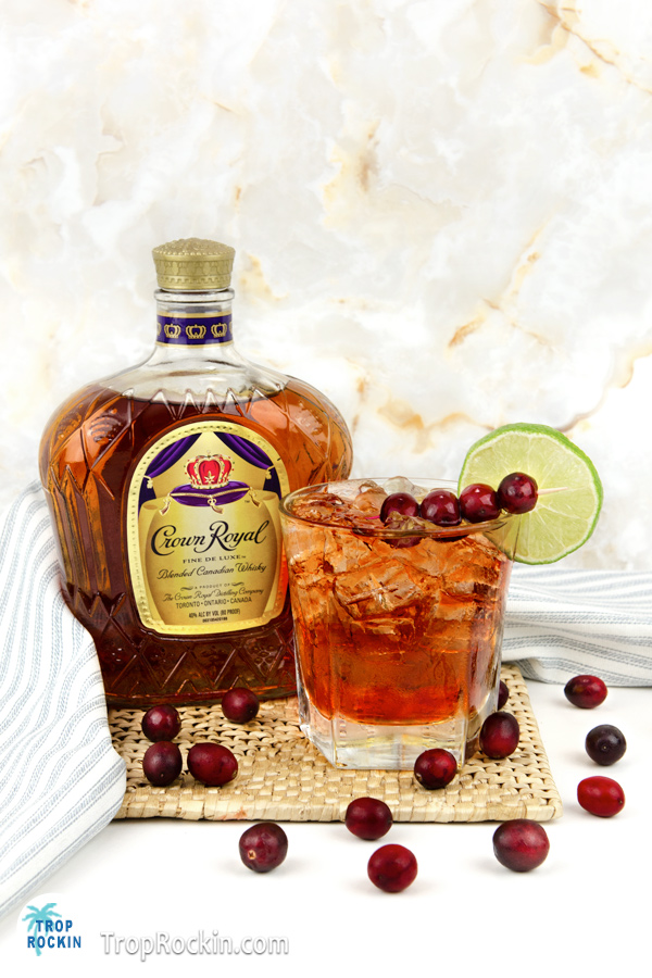 Crown royal bottle with crown and cranberry drink.