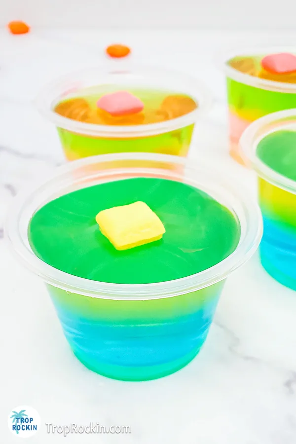 Two different starburst jello shots. Strawberry and watermelon in the background and the Blue Raspberry and Lemon Starburst Jello Shot in the foreground.