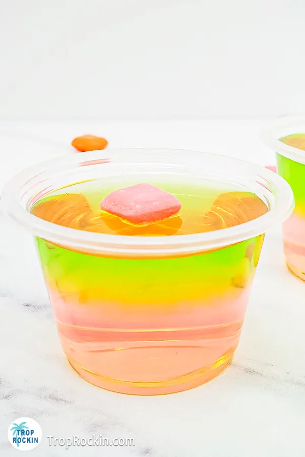 Starburst Duos Jello Shot with strawberry jello layered with watermelon jello topped with a pink starburst candy.
