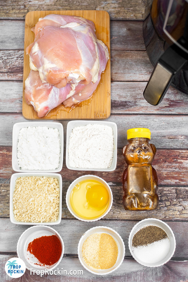 Air fryer panko chicken thighs ingredients displayed in bowls and cutting board on counter top.