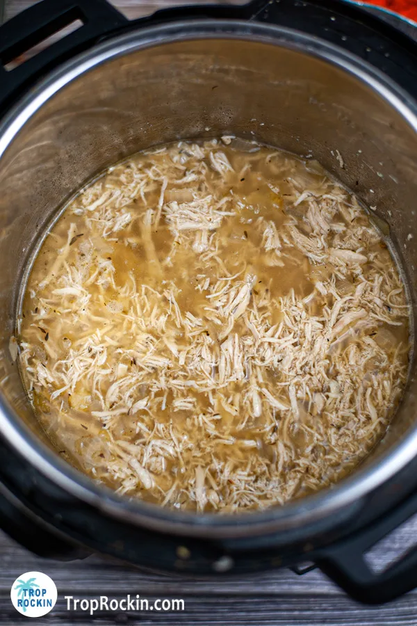 shredded chicken in broth and spices inside the instant pot.