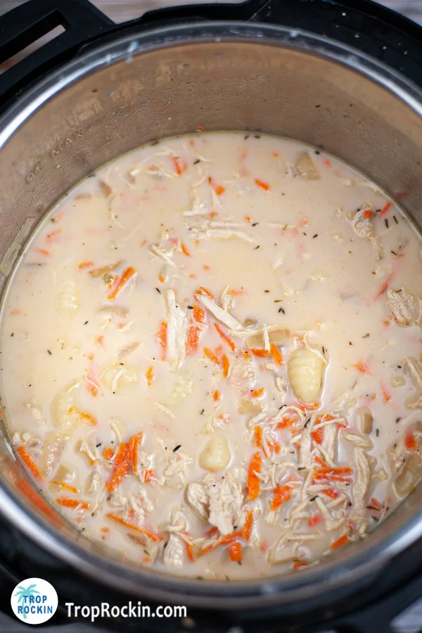creamy broth, carrots, spices and gnocchi inside the instant pot.