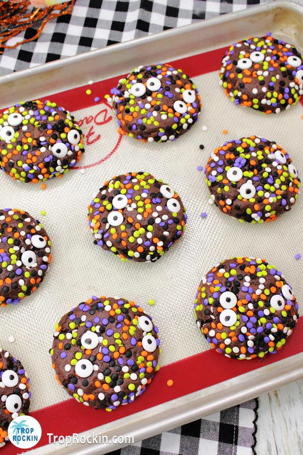 Halloween Sprinkle Cookies on a baking sheet covered with a silicone baking mat. 