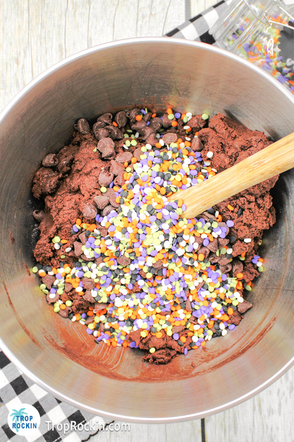 Added chocolate chips and Halloween sprinkles to the bowl of chocolate cookie dough.