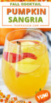 Pumpkin sangria in a glass with apple slices and a cinnamon stick. Text overlay on top of photo with recipe title.