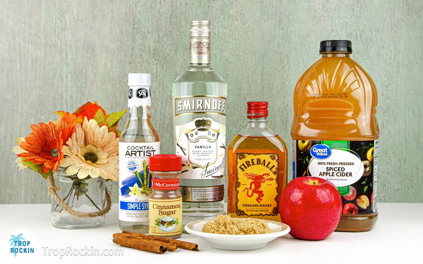 Apple pie cocktail ingredients displayed on counter top.