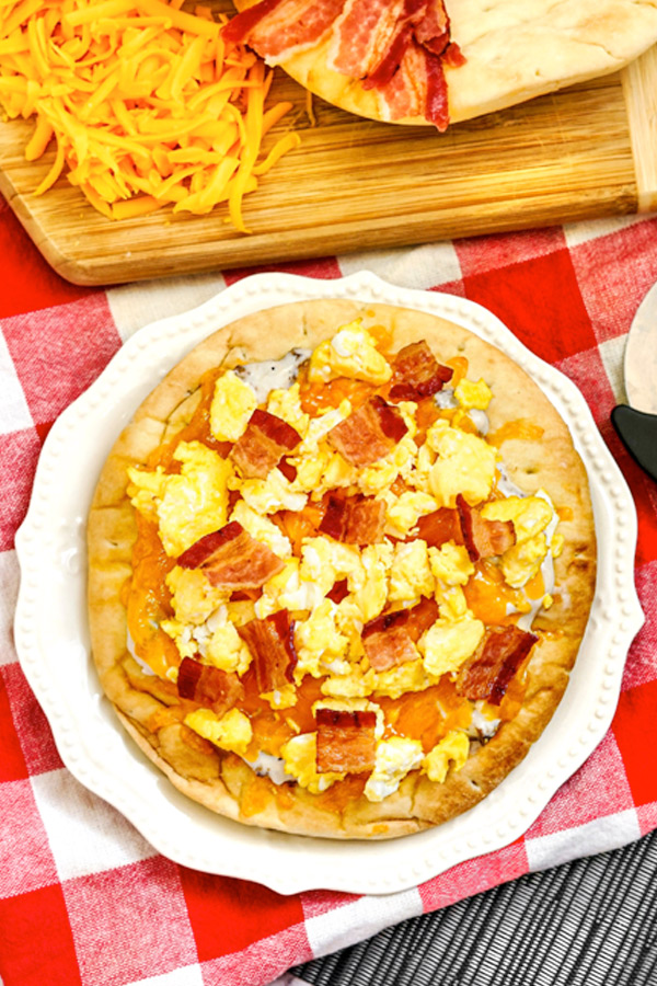 Upclose view of an Air fryer breakfast pizza on a white plate.